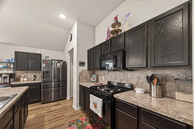 a kitchen with granite countertop a sink stove and refrigerator