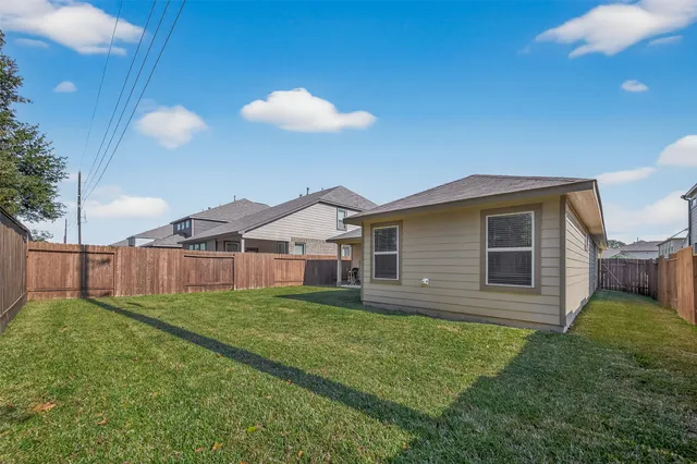 a view of a house with a yard and potted plants