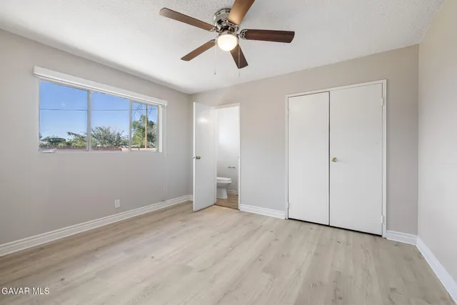 an empty room with a window and a ceiling fan