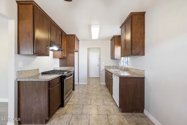 a kitchen with granite countertop a stove and a cabinets