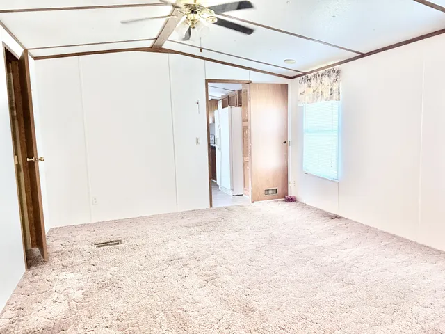 a view of a big room with wooden floor and windows