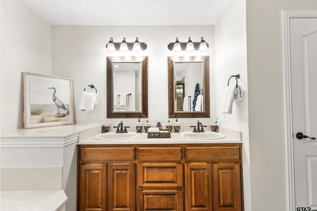 a bathroom with double vanity sink and a mirror
