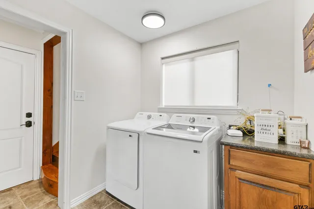 a utility room with cabinets washer and dryer
