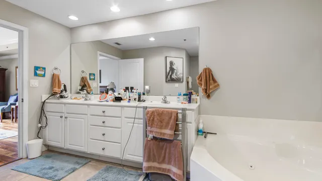 a bathroom with a bathtub sink a mirror and vanity