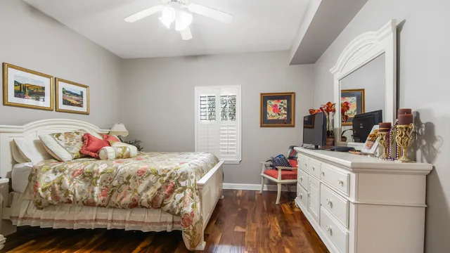 a bedroom with a bed and a large mirror on the dresser