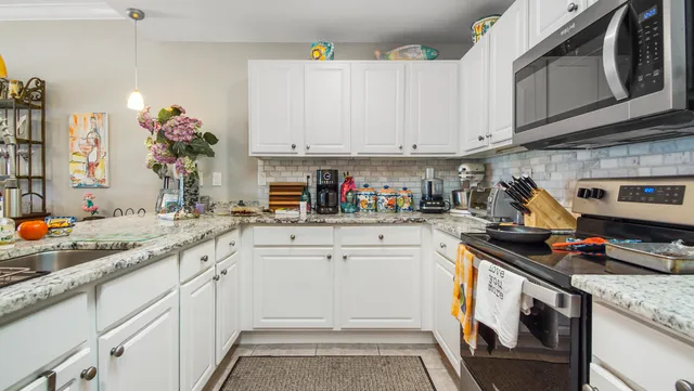 a kitchen with granite countertop white cabinets and white appliances