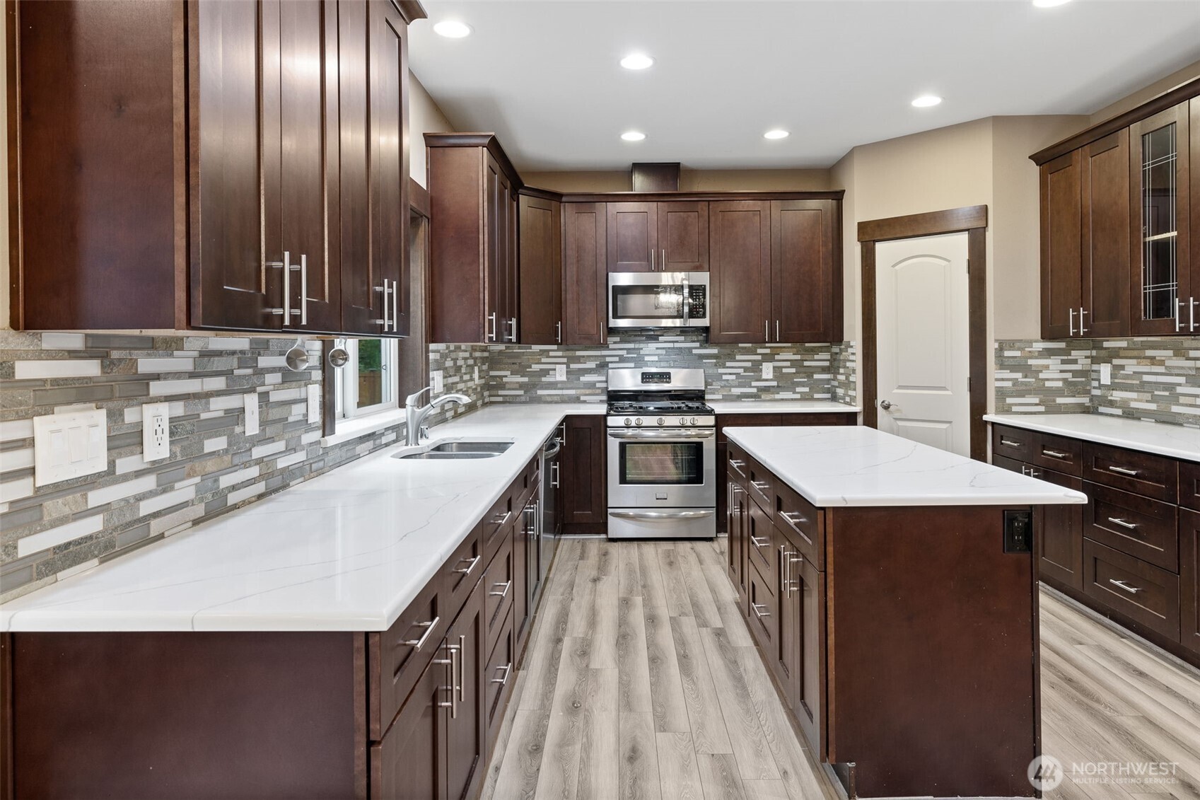 12801 218th Place Southeast Snohomish, WA 98296 - Photo 6 of 38 a kitchen with kitchen island stainless steel appliances a sink stove and refrigerator