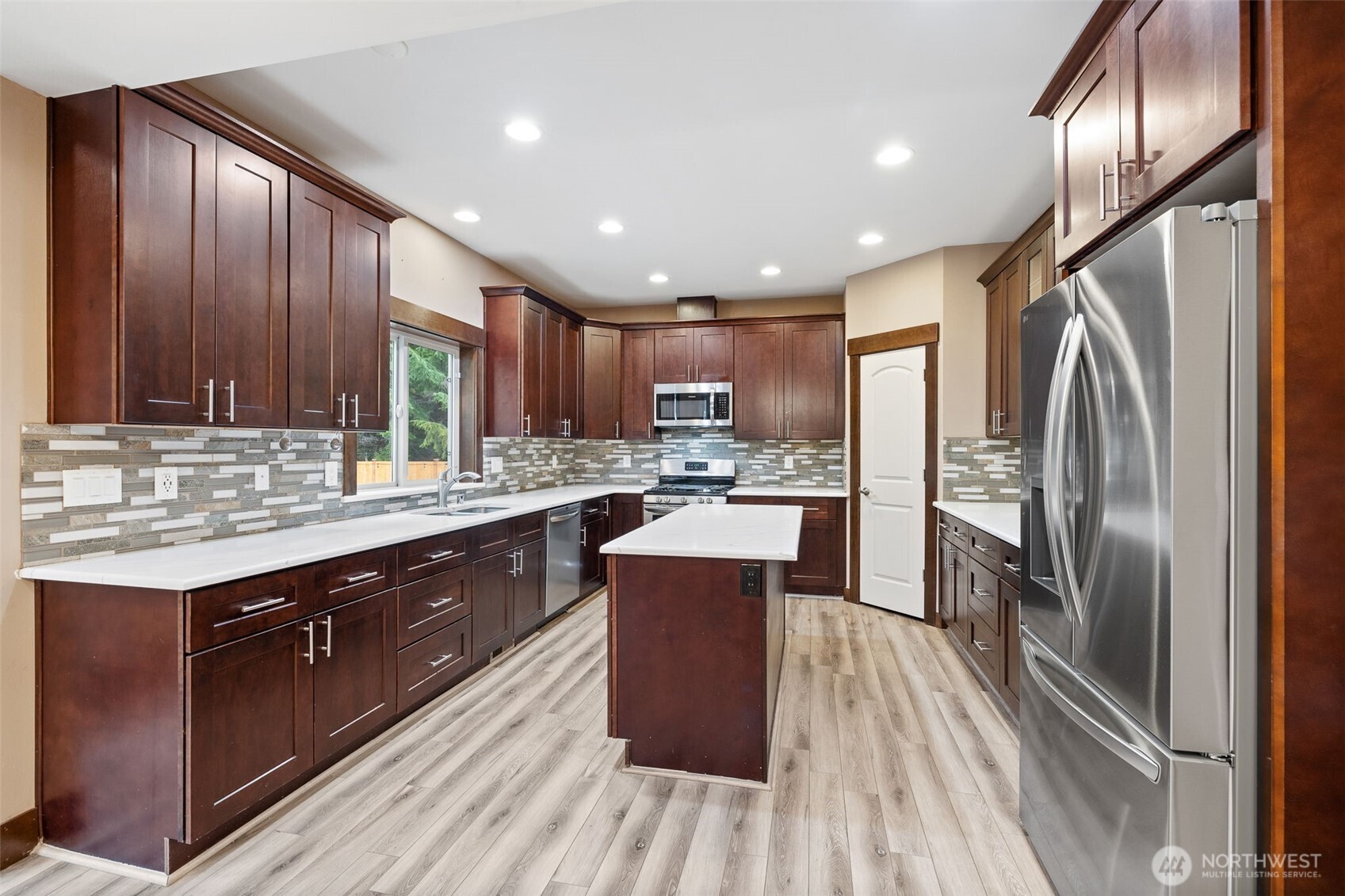 12801 218th Place Southeast Snohomish, WA 98296 - Photo 7 of 38 a kitchen with stainless steel appliances granite countertop a refrigerator a sink dishwasher a stove and a oven with wooden floor