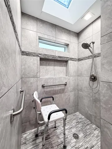 a living room with furniture a dining table wooden floor and a large window