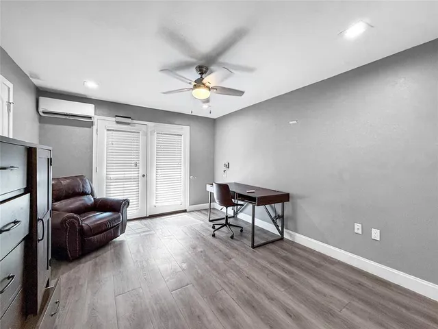 a view of a livingroom with wooden floor and a ceiling fan