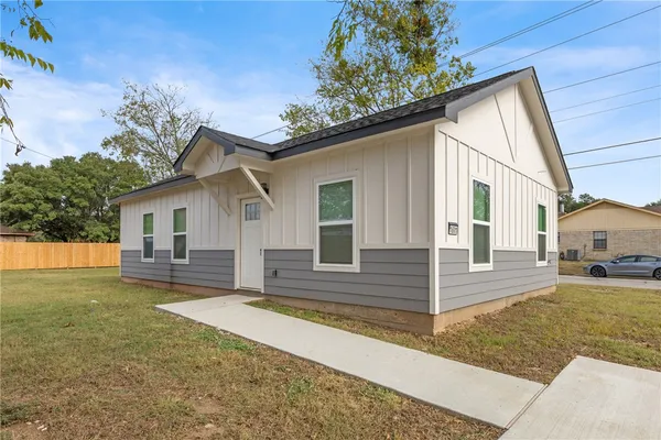 a view of a house with a yard and tree s