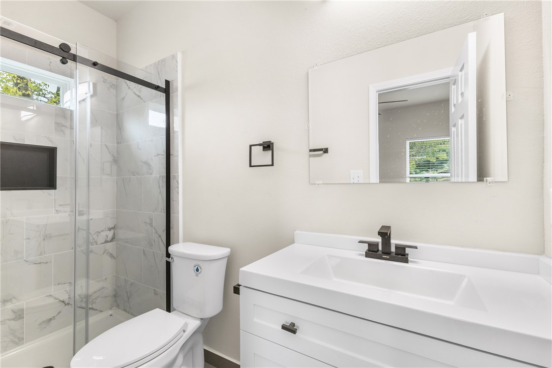 1601 West 17th Street Bryan, TX 77803 - Photo 11 of 16 a bathroom with a sink a toilet and shower