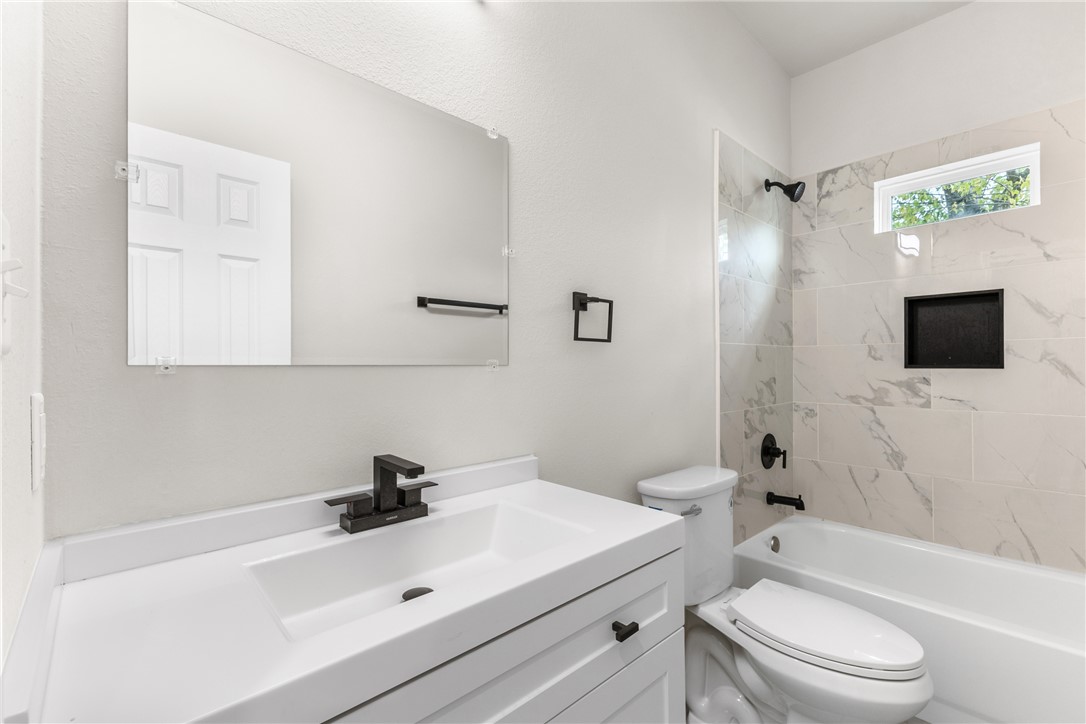 1601 West 17th Street Bryan, TX 77803 - Photo 8 of 16 a bathroom with a sink a toilet and shower