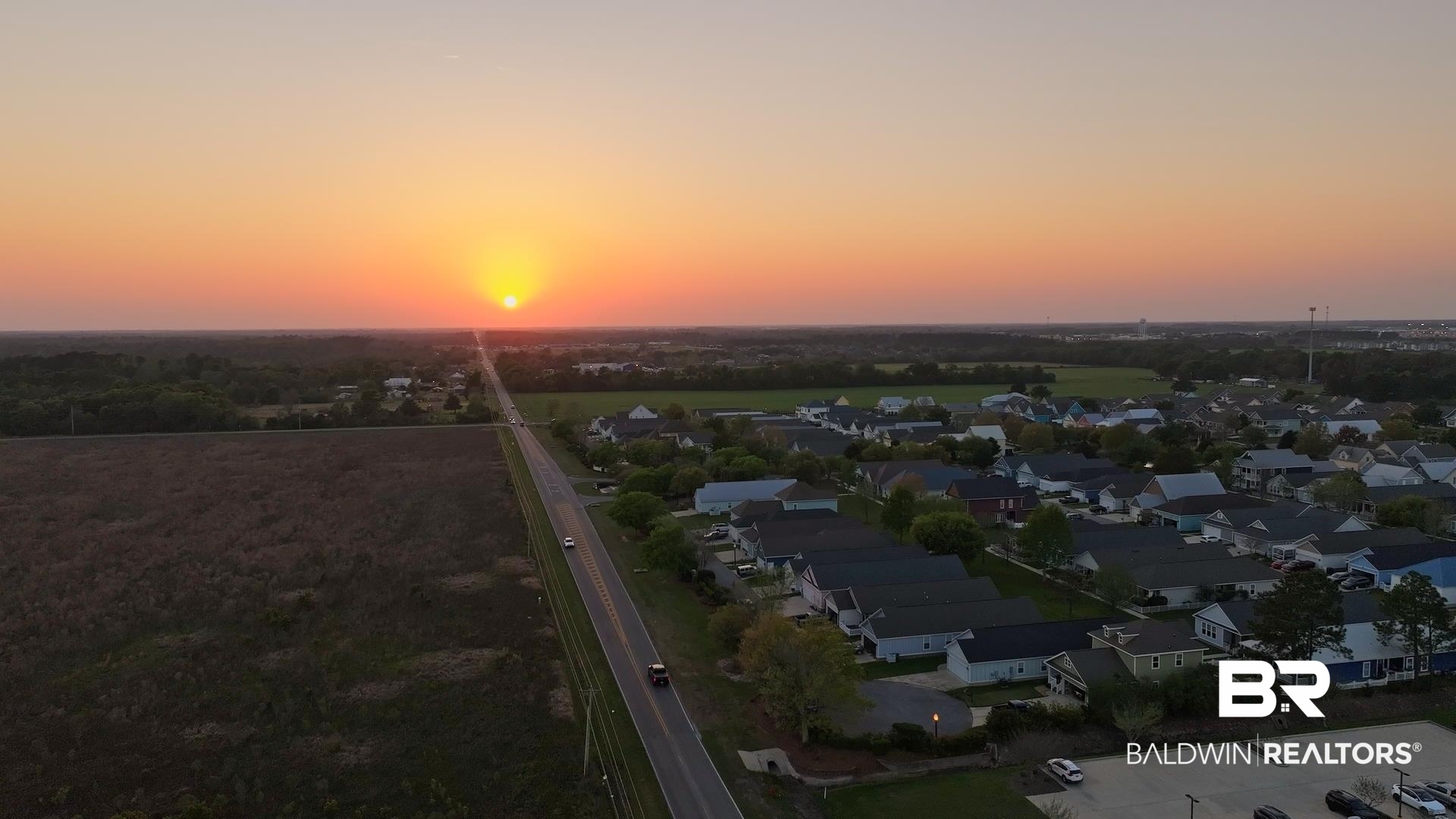 927 Periwinkle Lane Foley, AL 36535 - Photo 26 of 26 Expansive residential area with a prominent roadway, framed by open fields and distant foliage