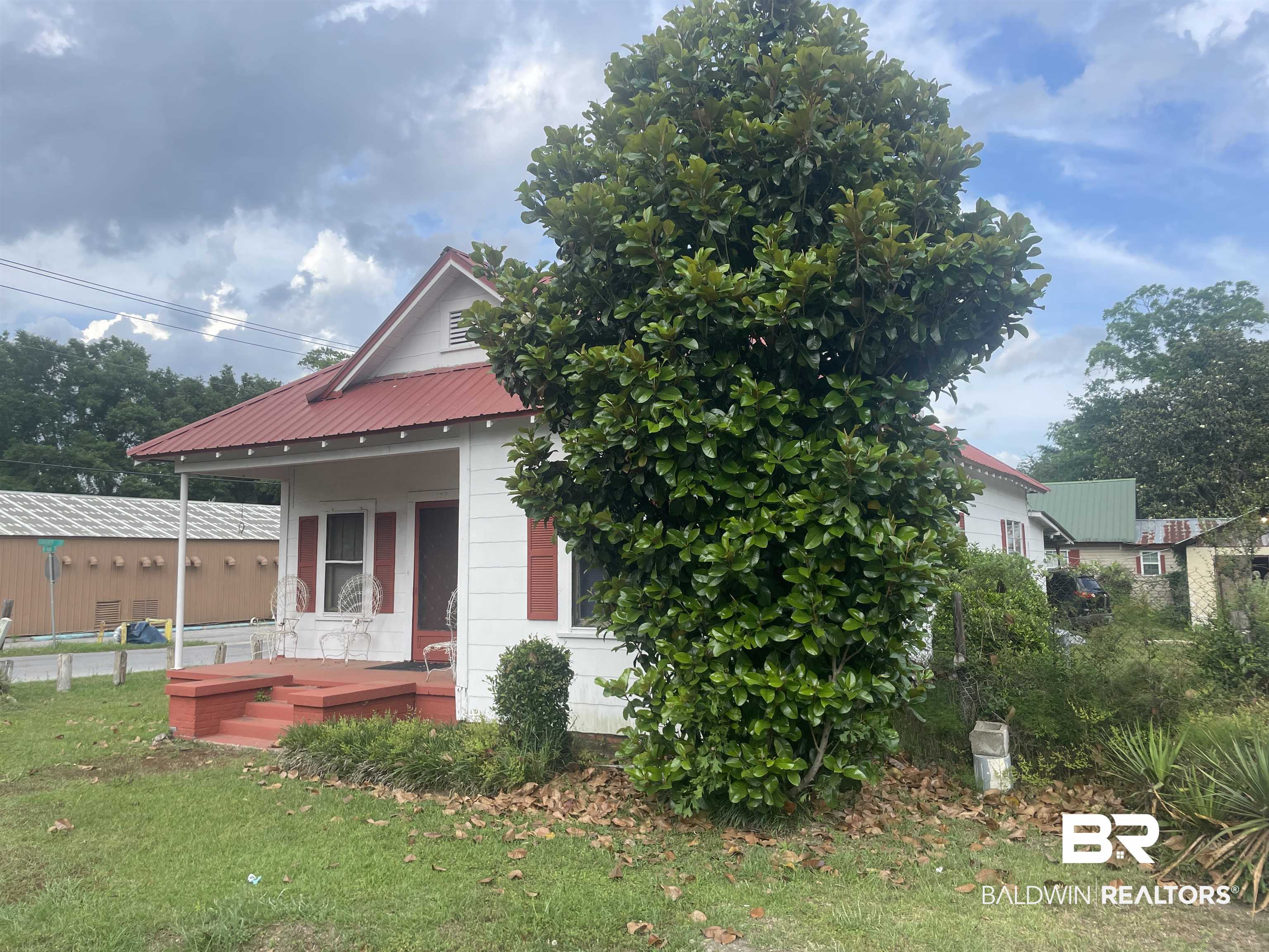 620 North Main Street Atmore, AL 36502 - Photo 2 of 7 White exterior with a red metal roof and red shutters