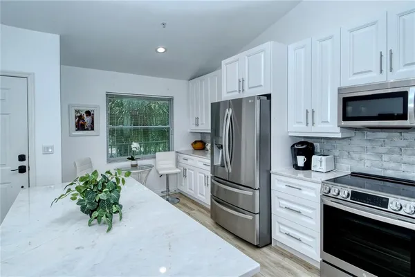 a kitchen with stainless steel appliances a refrigerator a stove a microwave a sink and cabinets