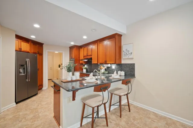 a dining hall with stainless steel appliances granite countertop a granite counter tops and a view of living room