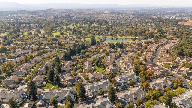 an aerial view of residential houses with city and mountain view