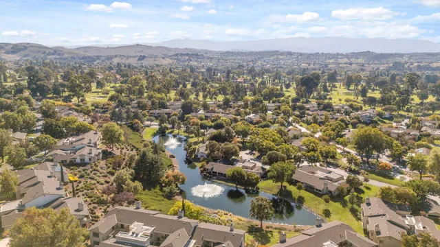 an aerial view of residential house with yard and mountain view in back