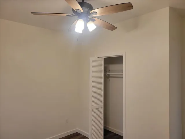 an empty room with a fan and a fan