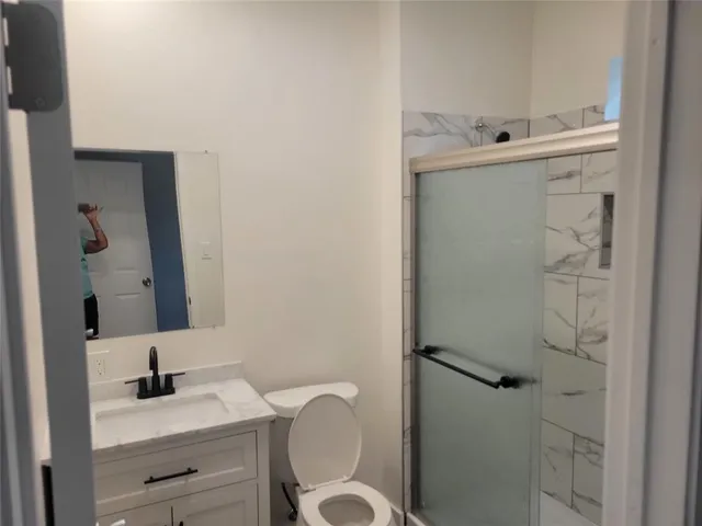 a bathroom with a sink vanity mirror and toilet