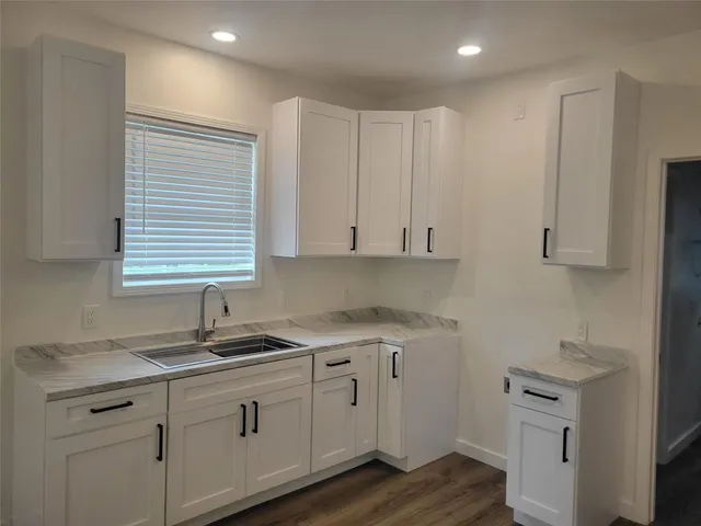 a kitchen with white cabinets a sink and dishwasher