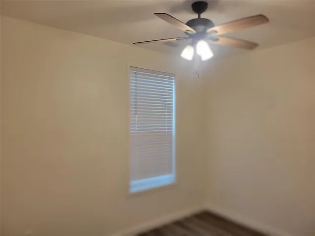 a view of empty room with window and fan