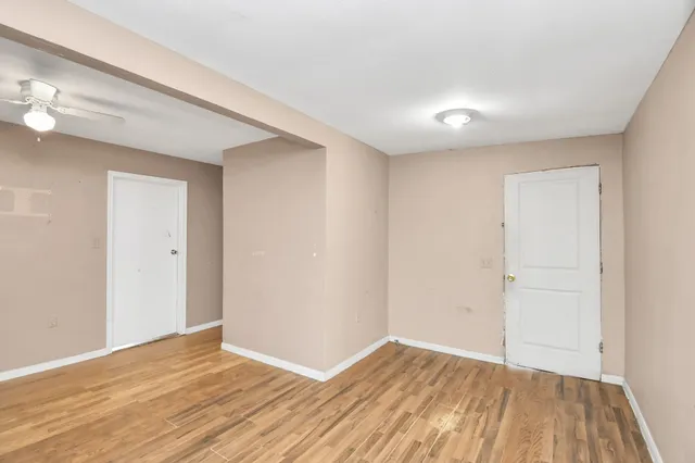 a view of an empty room with wooden floor