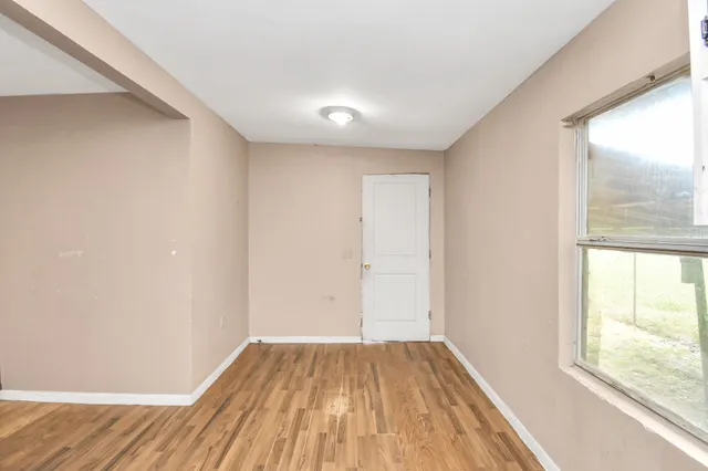 a view of a room with wooden floor and windows