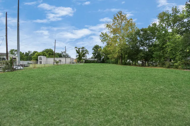 a view of a field of grass and trees