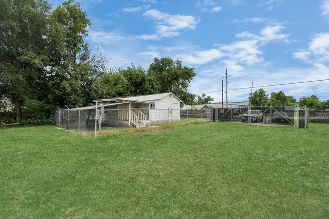 a view of a house with backyard and sitting area