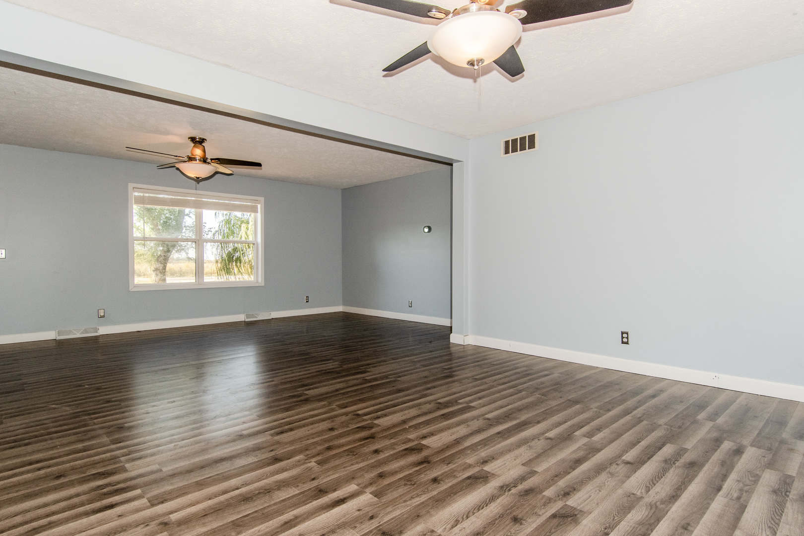2970 North Dwight Road Morris, IL 60450 - Photo 14 of 43 an empty room with wooden floor chandelier fan and windows