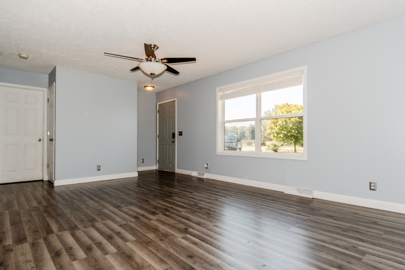 2970 North Dwight Road Morris, IL 60450 - Photo 18 of 43 an empty room with wooden floor chandelier fan and windows