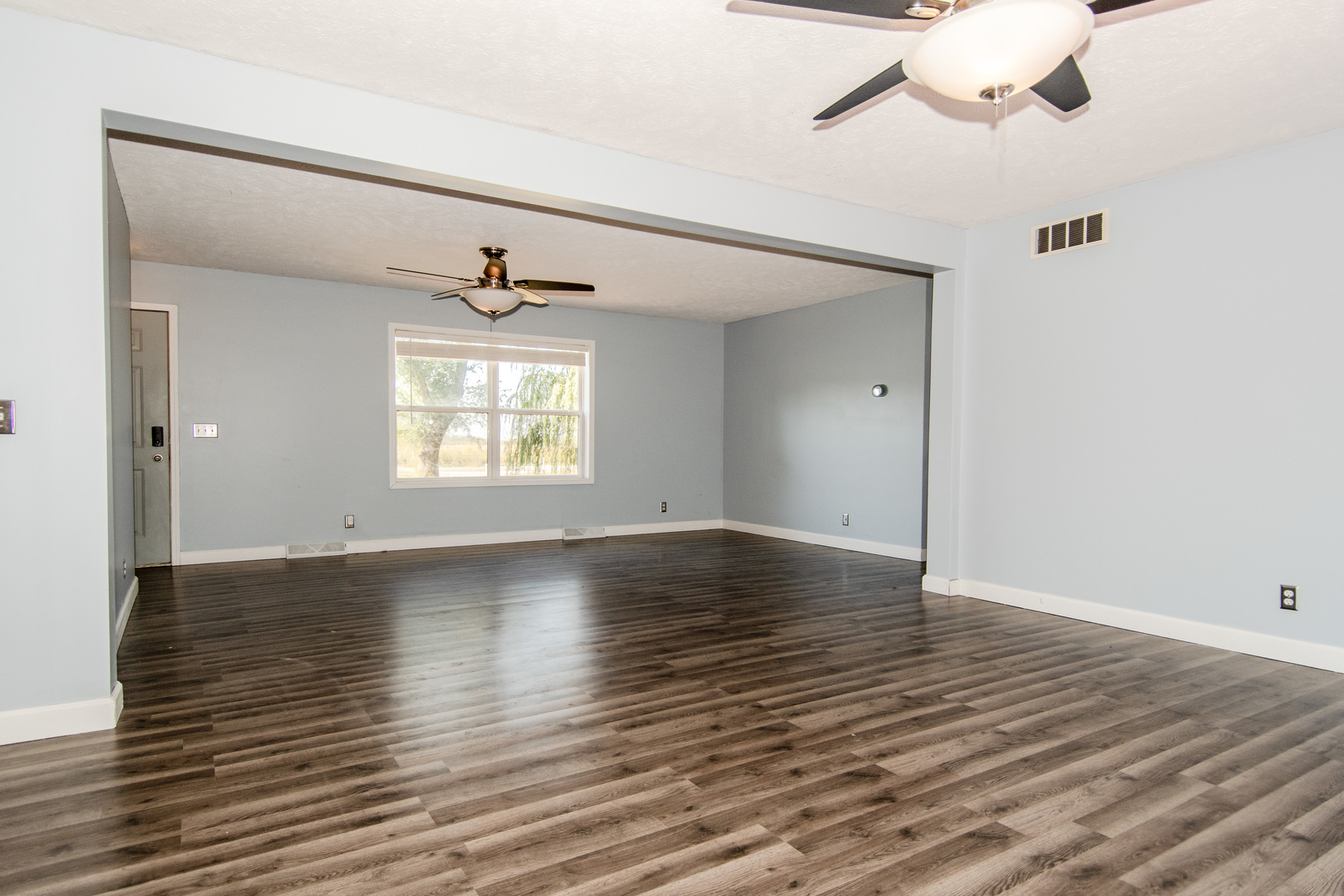 2970 North Dwight Road Morris, IL 60450 - Photo 21 of 43 an empty room with wooden floor chandelier fan and windows