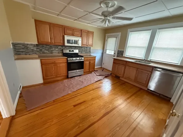 a kitchen with stainless steel appliances granite countertop a stove a sink and a microwave