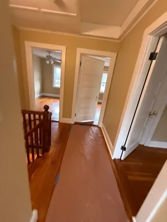 a view of a hallway with wooden floor and stairs