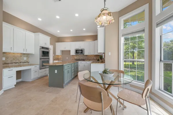 a kitchen with stainless steel appliances granite countertop a stove refrigerator and cabinets