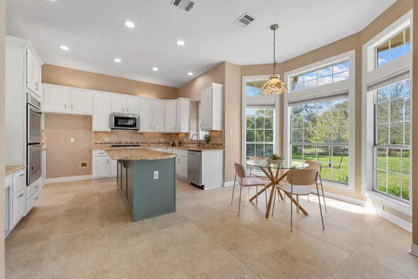 a kitchen with a table chairs refrigerator and chairs
