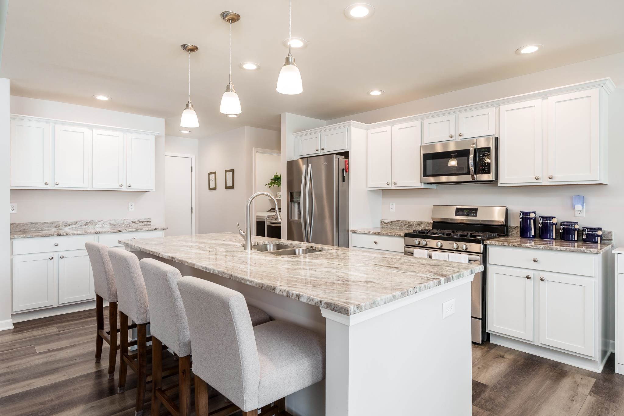 779 Boz Way Belvidere, IL 61008 - Photo 14 of 39 a kitchen with stainless steel appliances granite countertop a stove top oven a refrigerator a sink and a dining table with white cabinets