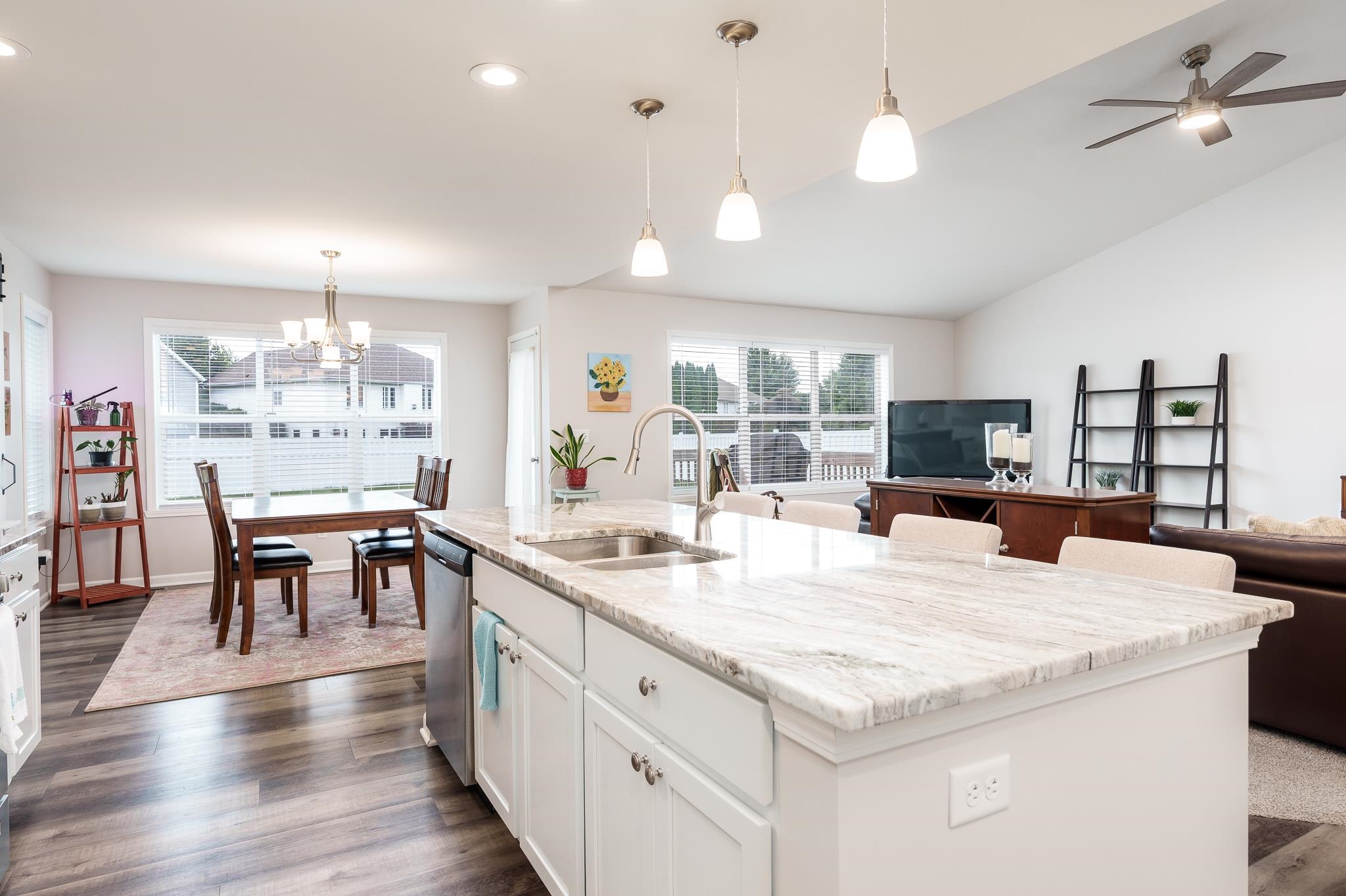 779 Boz Way Belvidere, IL 61008 - Photo 16 of 39 a large kitchen with kitchen island a stove a dining table and chairs with wooden floor