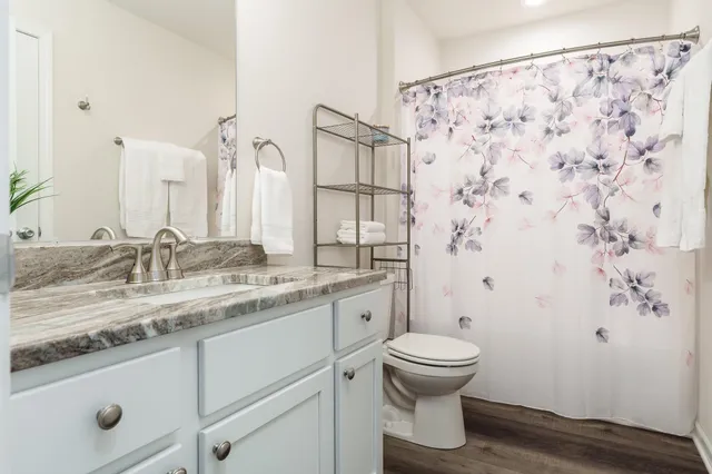a bathroom with a granite countertop sink toilet and shower