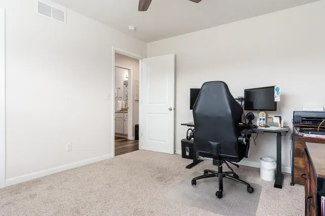 a view of a workspace with furniture and a window