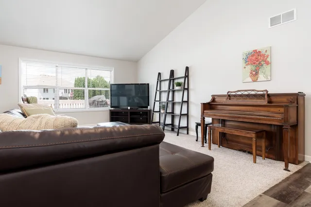a living room with furniture a large window and a flat screen tv