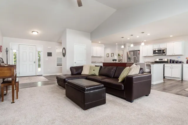 a living room with furniture and a dining table with kitchen view