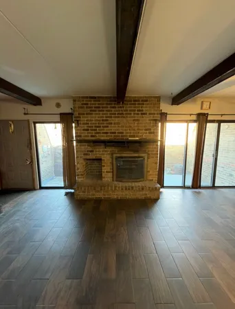 an empty room with wooden floor and fireplace