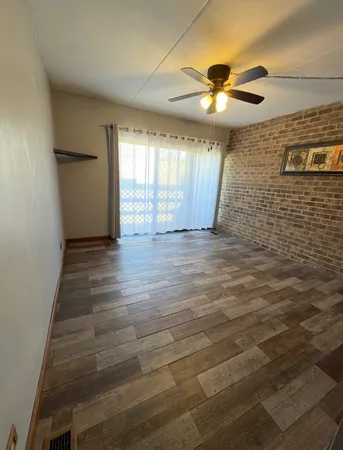 a view of a livingroom with wooden floor and a ceiling fan
