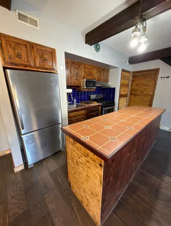 a kitchen with stainless steel appliances a stove a refrigerator and cabinets