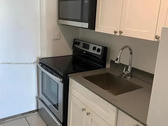 a close view of a sink and dishwasher in kitchen with stainless steel appliances