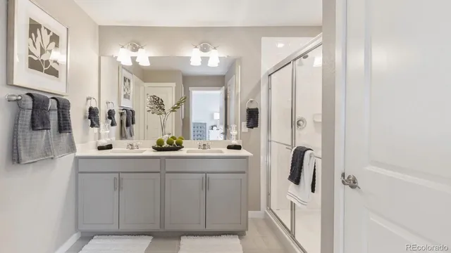 a bathroom with a double vanity sink mirror and shower