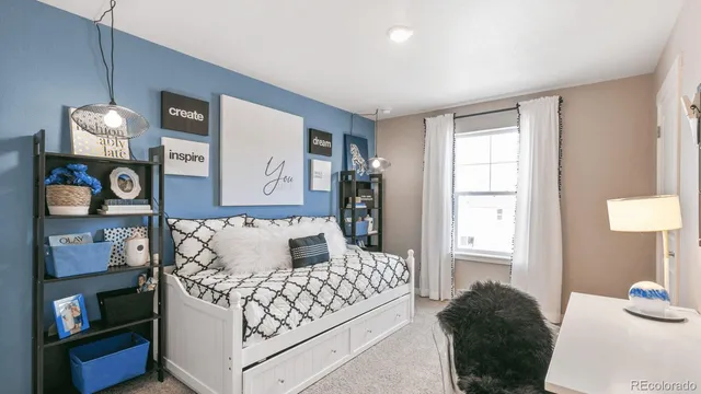 a bedroom with a bed and a lamp on dresser